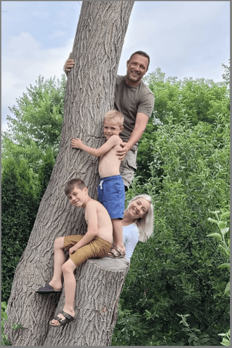 Photo of Jen Kanters and her family posing in front of a tree.